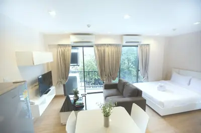a bedroom with a bed and a living room at Park 19 Hotel in Bangkok