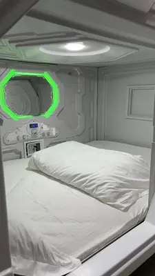 a bed in an airplane with a green light at Kiwi Capsule Hotel in Bangkok
