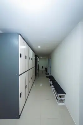 a hallway with a row of lockers in a locker room at Kiwi Capsule Hotel in Bangkok