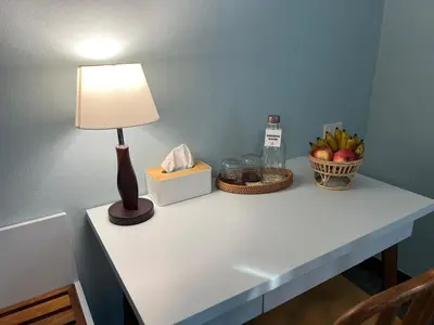 a table with a lamp and a basket of fruit at Dusita Residence in Bangkok