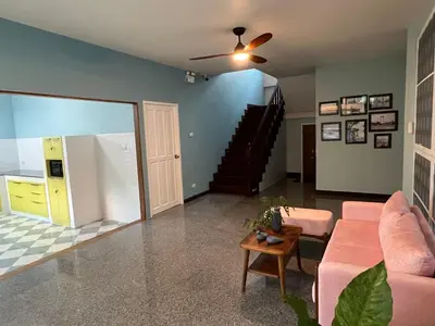 a living room with a pink couch and a staircase at Dusita Residence in Bangkok