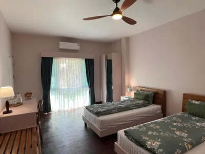 a bedroom with two beds and a ceiling fan at Dusita Residence in Bangkok