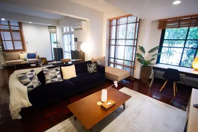 a living room with a couch and a table at Spacious 4-Bedroom Oasis in the Heart of Sukhumvit in Bangkok
