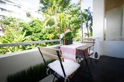 a balcony with two tables and chairs and a window at Spacious 4-Bedroom Oasis in the Heart of Sukhumvit in Bangkok
