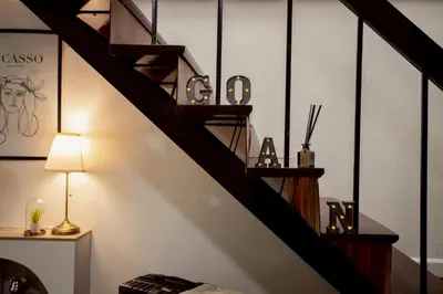 a staircase in a room with a lamp and shelves at Cosy Lodge MRT Phra Ram 9 in Bangkok