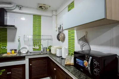 a kitchen with a sink and a microwave at Cosy Lodge MRT Phra Ram 9 in Bangkok