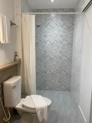 a bathroom with a toilet and a shower at Squirrel House in Bang Rak