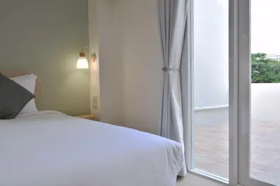a bedroom with a bed and a sliding glass door at Squirrel House in Bang Rak