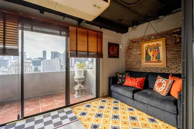 a living room with a couch and a large window at PEONY Rustic Apartment Sukhumvit, Nana BTS in Bangkok