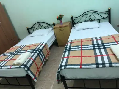 two beds sitting next to each other in a room at PTT Mansion ปทิตา แมนชั่น in Ban Zong Katiam