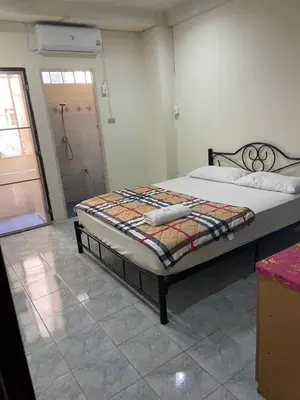 a bedroom with a bed and a door to a bathroom at PTT Mansion ปทิตา แมนชั่น in Ban Zong Katiam