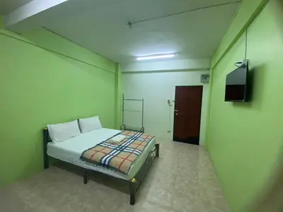 a bedroom with a bed and a television in it at PTT Mansion ปทิตา แมนชั่น in Ban Zong Katiam