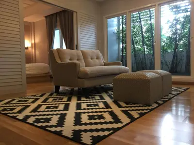 a living room with a couch and a chair and a rug at K Maison Boutique Hotel in Bangkok