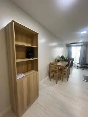 a living room with a table and a wooden book shelf at MeStyle Sukhumvit Banana มีสไตล์สุขุมวิท บางนา in Bangna