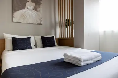 a bedroom with a bed with blue and white sheets at Nature Boutique Hotel Ratchayothin in Bangkok