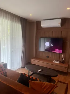 a living room with a couch and a flat screen tv at Spacious Bedroom- 2 mins from Train Station in Bangkok