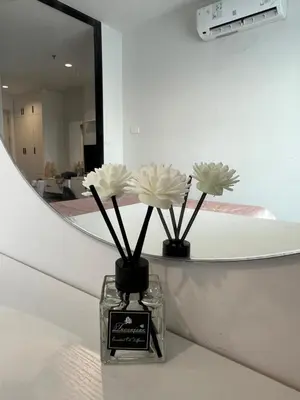 a vase with flowers in front of a mirror at GM bangson home in Bangkok