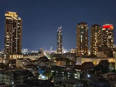 a city skyline at night with tall buildings at The Central Bangkok Station1 in Bangkok