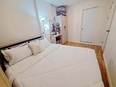 a white bedroom with a large white bed with white pillows at A family room at Lumpini Ville Sukhumvit 101-1 by Pikul in Bangkok