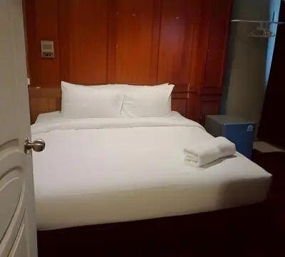a bed with white sheets and pillows in a room at xx Stay On Sukhumvit 11 BTS Nana in Bangkok