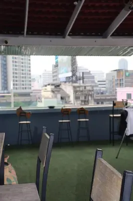 a room with chairs and a view of a city at The Moment Hostel in Bangkok