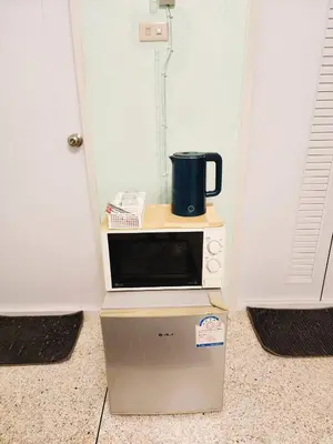 a microwave sitting on top of a box with a mug on it at 703-STP Homely room Free Wi-Fi and Near BTS line in Bangkok
