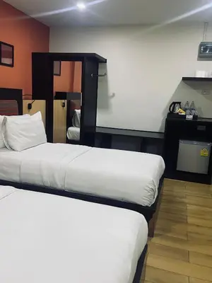 a hotel room with two beds and a projection screen at Residency Hotel Bangkok in Bangkok