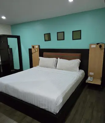 a bedroom with a large bed with white sheets at Residency Hotel Bangkok in Bangkok
