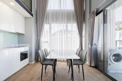 a dining room with a white table and chairs at loft \u4e8c\u623f\u53ef\u4f4f4\u4eba \u8fd1jodd\u591c\u5e02 \u6e38\u6cf3\u6c60 in Bangkok