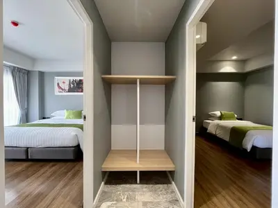 a bedroom with two beds and a mirror at iCheck inn Thapra in Bangkok