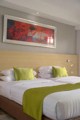 a bedroom with two beds and a painting on the wall at iCheck inn Thapra in Bangkok