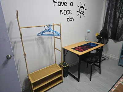 a room with a desk and a shelf and a table at 104 Peaceful and Cosy apartment near BTS with free WiFi in Bangkok