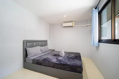 a bedroom with a bed in a room with a window at OH Hostels - Bangkok in Bangkok
