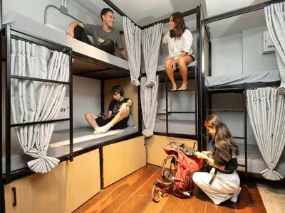 a group of people sitting on bunk beds at OH Hostels - Bangkok in Bangkok