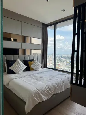a bedroom with a large bed with a large window at The Esse Asoke in Bangkok