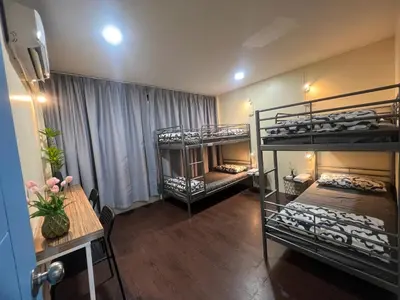 a room with two bunk beds and a table and a tableablishthritisthritisthritis at Youjia Youth Hostel in Bang Rak