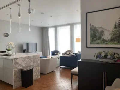 a living room with a kitchen and a living room with a couch at Ritz Carlton Residences in Bangkok