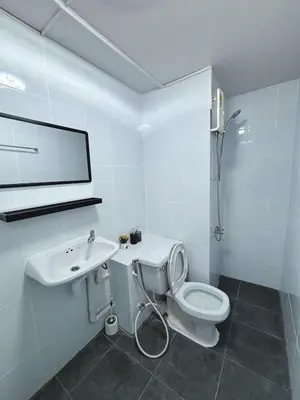 a white bathroom with a toilet and a sink at Impact - Don Mueng Condo C5 in Thung Si Kan