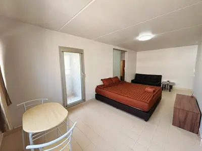 a bedroom with a bed and a table and a chair at Impact - Don Mueng Condo C5 in Thung Si Kan