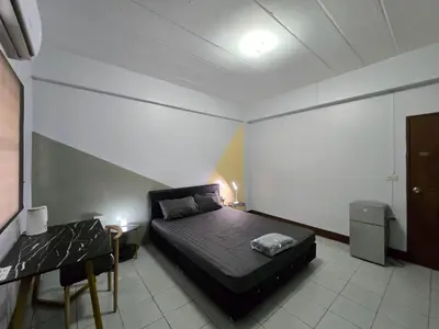 a small bedroom with a bed and a table at SRINN House, Bangkok in Bangkok