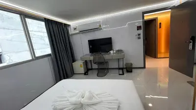 a room with a white bed and a television at Golden Mango home hotel \u91d1\u8292\u679c\u4e4b\u5bb6\u9152\u5e97 in Bangkok