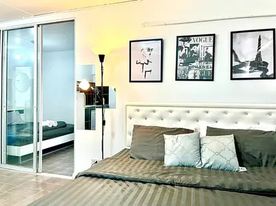 a bedroom with a bed and some pictures on the wall at Impact Arena Condo 2Rooms C3 by GoodRoom24 in Ban Bang Phang