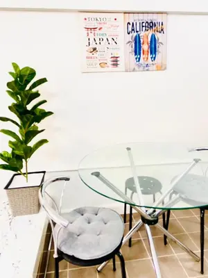 a glass table with two chairs and a plant at Impact Arena Condo 2Rooms C3 by GoodRoom24 in Ban Bang Phang