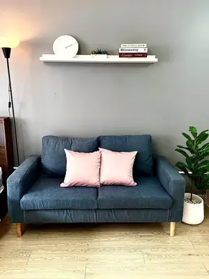 a blue couch with two pink pillows on it at Impact Arena Condo 10fl by GoodRoom24 in Ban Song Hong