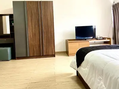 a hotel room with a bed and a television at Impact Arena Condo 10fl by GoodRoom24 in Ban Song Hong