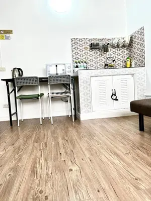 a kitchen with wooden floors and a counter with chairs at Impact Arena Condo Twin Beds by Goodroom24 in Ban Song Hong