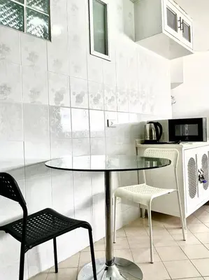 a kitchen with a glass table and two chairs at Impact Arena Condo C1 by GoodRoom24 in Ban Song Hong