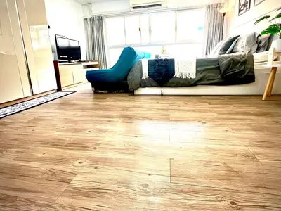 a living room with wood floors and a couch at Impact Arena Condo C3 by GoodRoom24 in Ban Bang Phang
