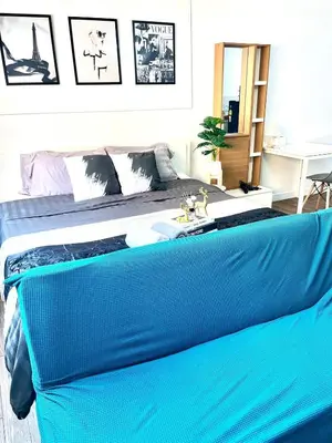 a bedroom with a bed with a blue blanket at Impact Arena Condo C3 by GoodRoom24 in Ban Bang Phang