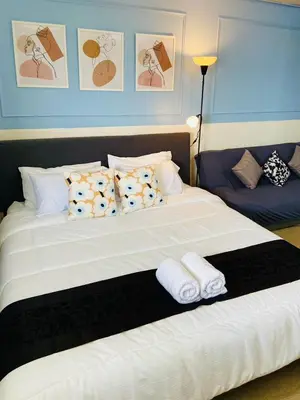 a bedroom with a large white bed with pillows at Impact Arena Condo TwoTone By GoodRoom24 in Ban Song Hong